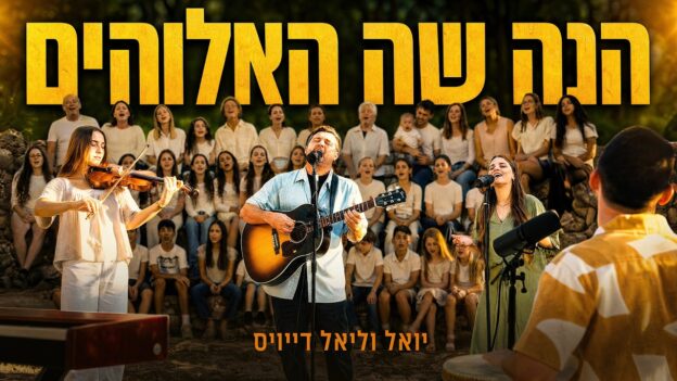 Outdoor choir performance with a guitarist and two lead vocalists in front of a white-clad chorus and seated audience; large Hebrew banner text above.