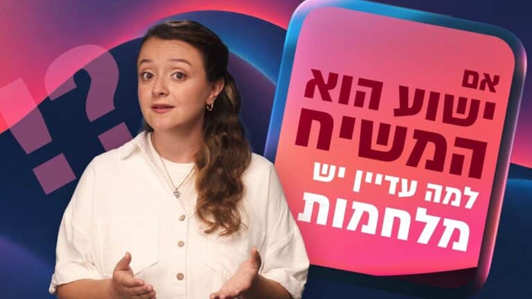 Woman in a white shirt explains something, standing beside a large pink panel with bold Hebrew text on a colorful background.